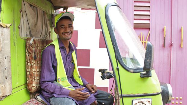 A young man in the drivers seat of a Tuk Tuk in Pakistan